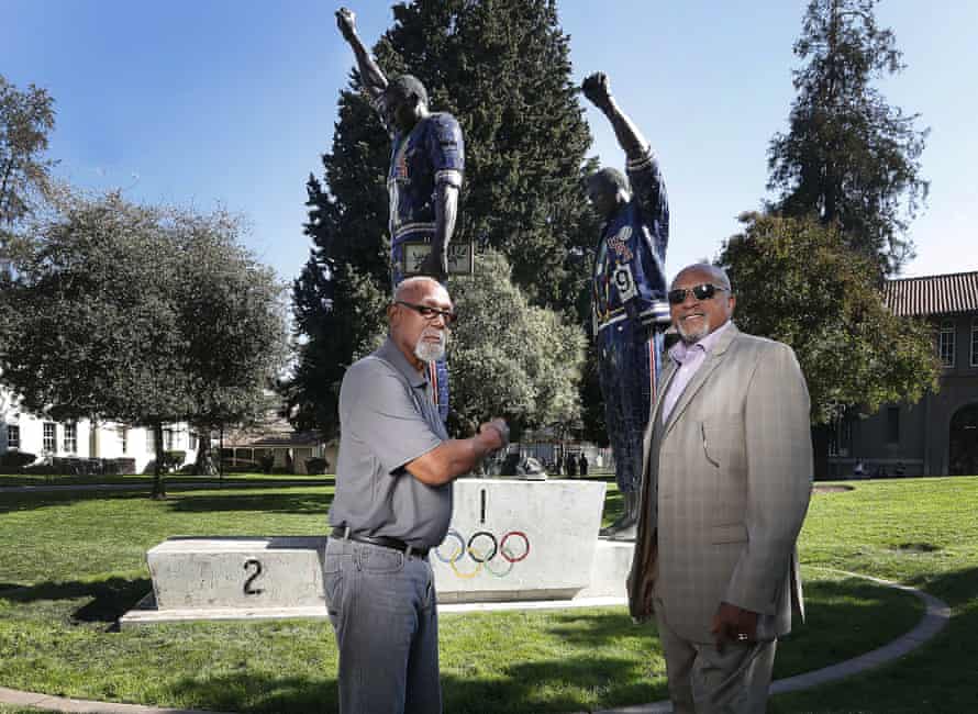 Carlos (left) and Smith in front of a statue of their protest at San Jose State University.