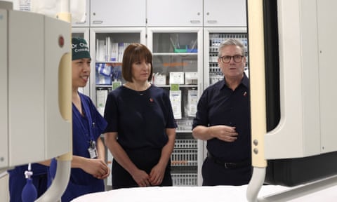 Member of hospital staff, Reeves and Starmer looking at hospital equipment