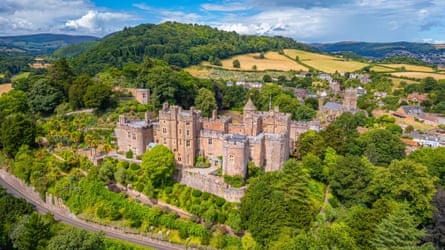 A castle surrounded by a hill and trees