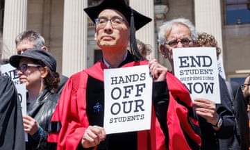 professors hold signs that read "hands off our students"
