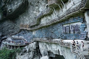 Bookshelves and walkways fixed onto an ancient rock wall
