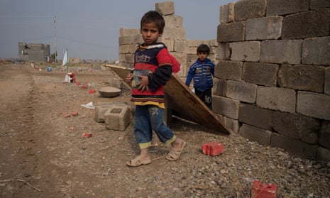 Children in Fallujah emerge from the garden of an abandoned house that has not been swept for unexploded ordnance