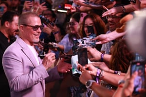 Brad Pitt gives autographs as fans hold out photos for him to sign