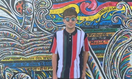 Martin in sunglasses standing in front of a wall of graffiti