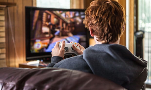 A teenager playing video games at home.