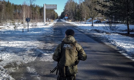 A member of the Ukrainian State Border Guard stands watch at the border crossing between Ukraine and Belarus  