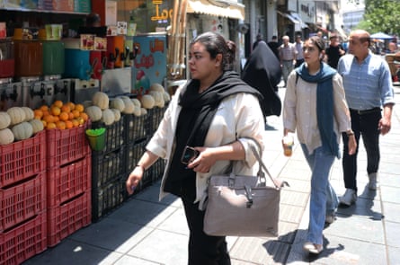 Iranians walk along a street in Tehran.