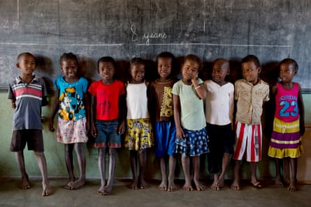 Zara, aged eight (fourth from left) stands with other children beneath a chalk line indicating how tall children aged eight should be, at their primary school in Bemanonga commune, near Morondava, Madagascar. A teacher says 70-80% of children are malnourished