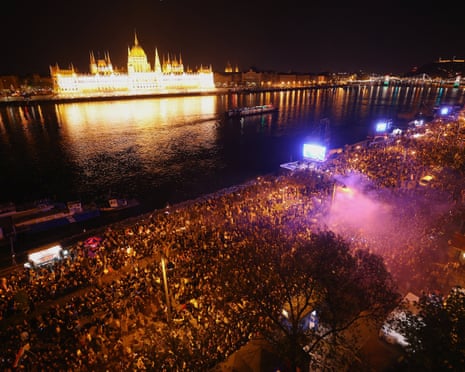 People celebrate across the River Danube from the parliament building, following the partial results of the parliamentary election, in Budapest, Hungary.