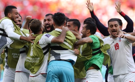 Iran players hug in celebration at the Ahmad Bin Ali Stadium
