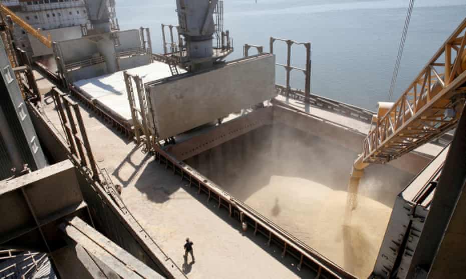 A dockyard worker watches as barley grain is poured into a ship in Nikolaev.