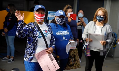 First-time voter and new US citizen Salvadora Martir, left, waves to onlookers after casting her ballot at Dodger Stadium in Los Angeles, California.