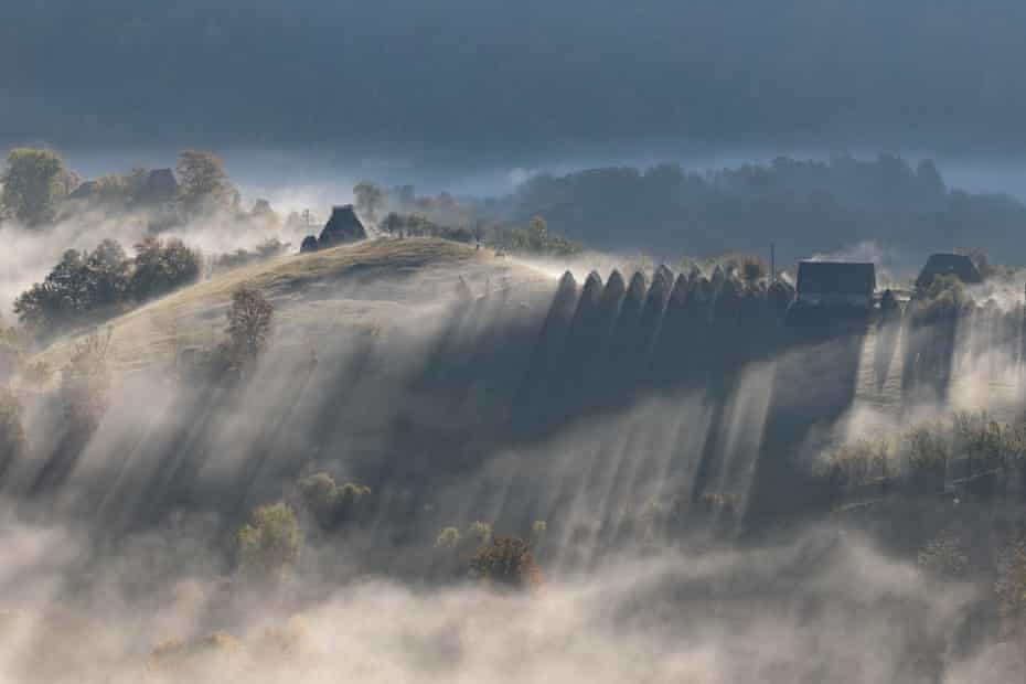 Conical haystacks on misty hilltop