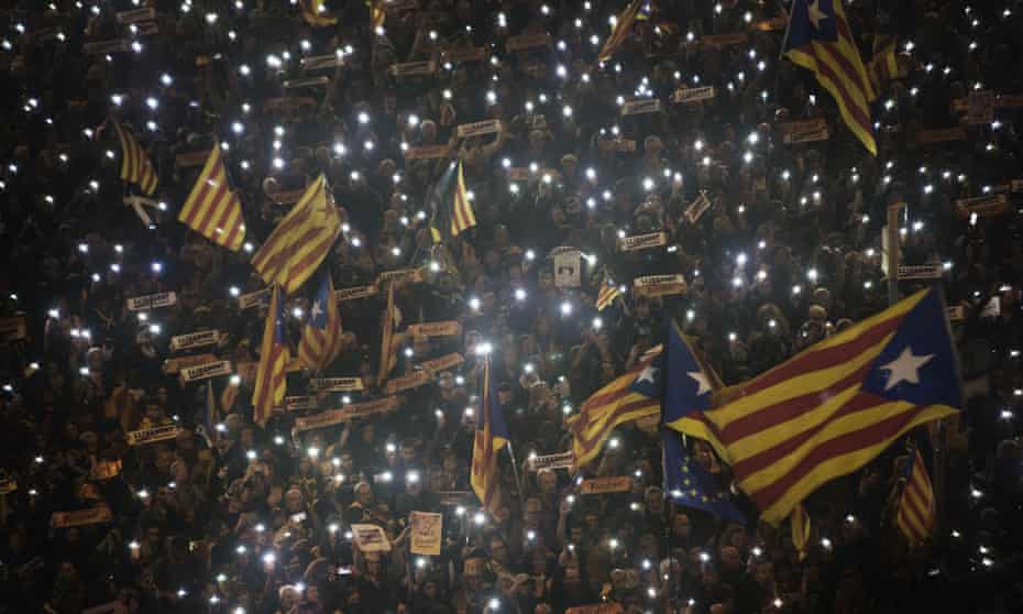 Supporters of Catalan independence wave lights and flags at a march in Barcelona on Saturday