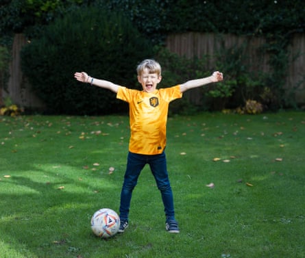 England’s united nations of football: 32 teams, one World Cup – and a lot of excited kids | World Cup 2022 23 Lasse van de Lagemaat wearing a Netherlandsshirt and standing with a football, with his arms and legs outstretched in a garden