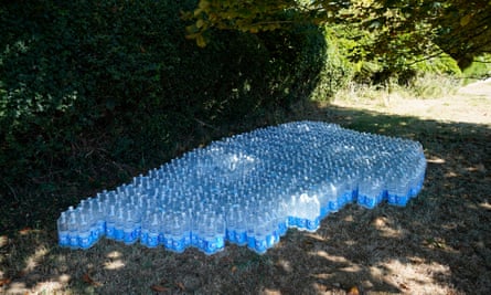 Bottles of water under the shade of a hedge
