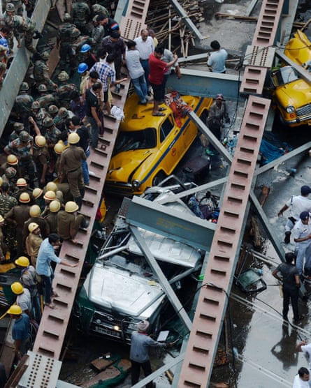 Indian rescue workers and volunteers try to free people trapped under the wreckage of the flyover.