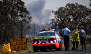 Smoke from a large bushfire is seen from a roadblock outside Wytaliba, near Glen Innes, on Sunday