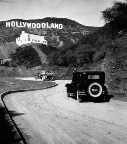car drives toward hollywoodland sign