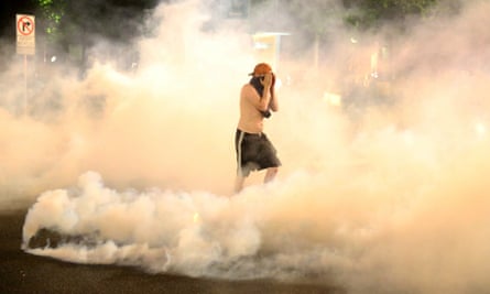 A demonstrator covers his face as teargas envelops him during protests in Portland, Oregon, on 29 March.