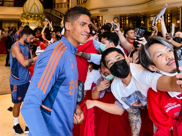 Raphaël Varane poses with fans before United's first training session in Bangkok.