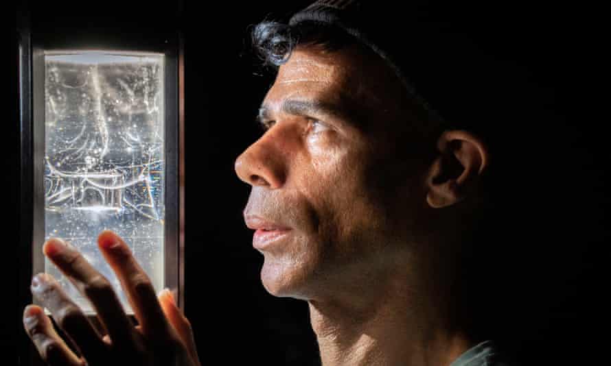 Artist Wayne Binitie with his glass sculpture containing air from the year 1765