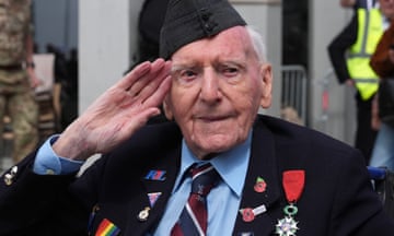 British veteran Bernard Morgan from Crewe, aged 100, salutes as he arrives for a parade in Arromanches-les-Bains, France.