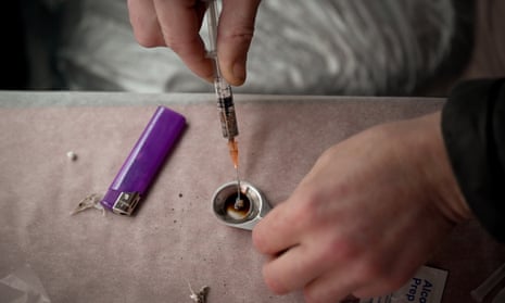 A heroin user prepares a syringe in a safe consumption van in Glasgow.