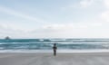 Lonely person standing by the sea, looking out into the distance in Dunedin, Otago, South Island, New Zealand