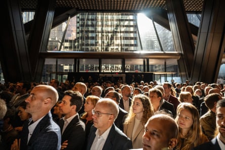 people attend a ribbon cutting ceremony inside the JPMorgan Chase & Co building with manhattan skyscrapers visible in the background