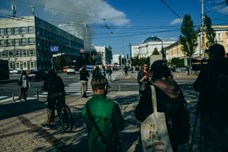 People look on as smoke rises in Kyiv