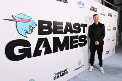 man stands in front of sign that says 'beast games'