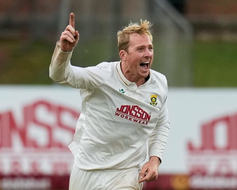 Simon Harmer points upward, celebrating a wicket with an excited shout