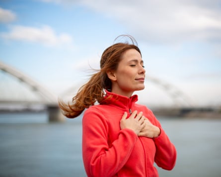 Woman feeling mindful and grateful outdoors with closed eyes