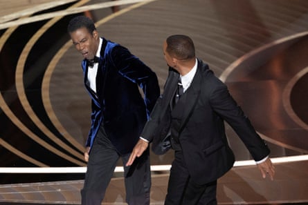 Will Smith (R) hits Chris Rock as Rock spoke on stage during the 94th Academy Awards in Hollywood, Los Angeles, California, U.S., March 27, 2022.