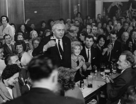 Harold Wilson pictured in 1964 raises a glass of beer in a packed meeting hall