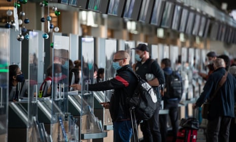 Passengers check in for flights. The UK will be tightening travel rules amid Omicron spread.