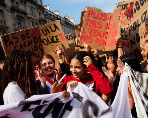 Crowd of young people smiling and waving placards
