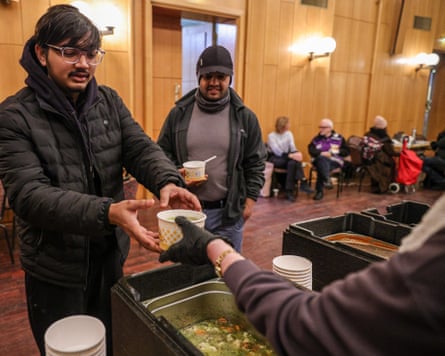 Volunteers offer food to sheltering people at an aid station in the Steglitz-Zehlendorf district.
