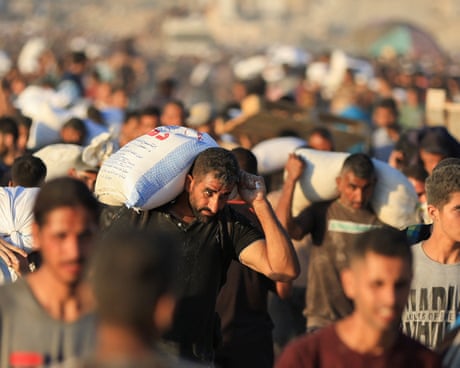 Palestinians carrying aid