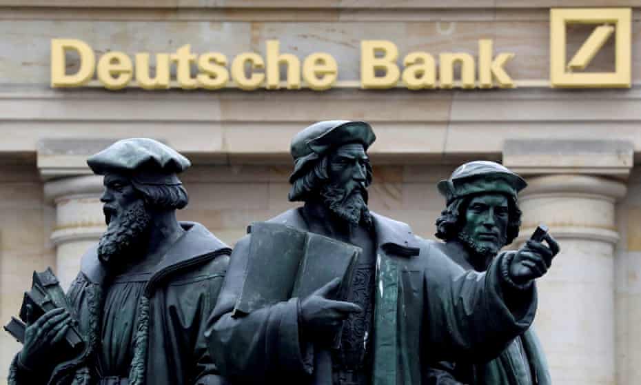 A statue is pictured next to the logo of Germany’s Deutsche Bank in Frankfurt