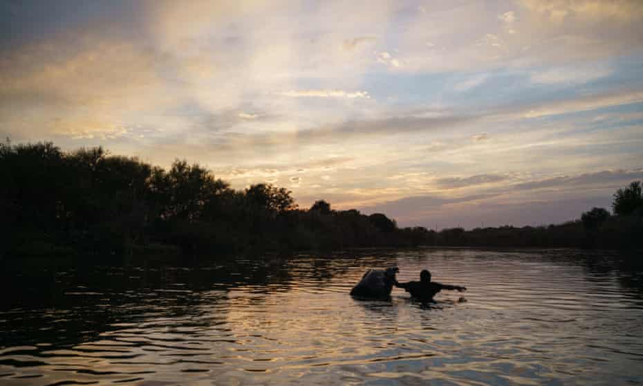 A Haitian man crosses the Rio Grande near Ciudad Acuna, Mexico, to the encampment on the Del Rio, Texas, side of the border.