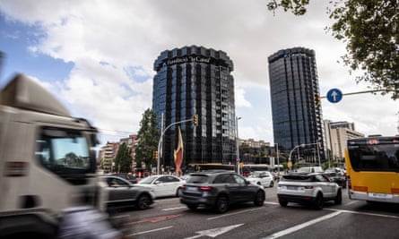 Traffic passes the Caixabank SA headquarter buildings in Barcelona, Spain