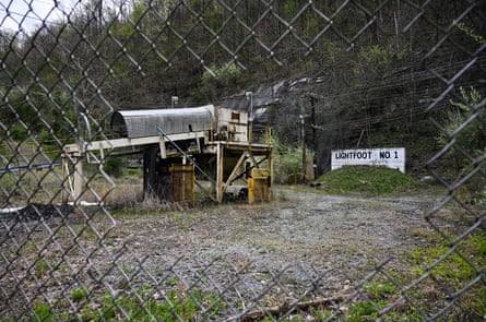 a broken fence with a coalmine in the back