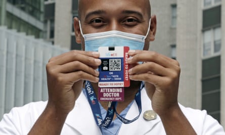 Alister Martin, an emergency room doctor at Massachusetts General Hospital, holds up a voter information card he wears on his ID.