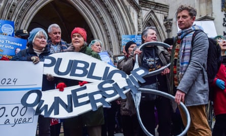 Protesters hold giant scissors with a ‘Public ownership’ message during the demonstration outside the Royal Courts of Justice calling on the court to block the Thames Water application for a £3bn emergency loan