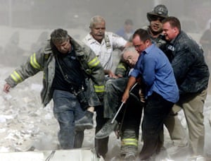 Rescue workers carry fatally injured New York City Fire Department Chaplain, the Rev. Mychal Judge, from the World Trade Center in New York City, 11 September, 2001. “I will never forget the call from my bureau chief ” says Shannon Stapleton “Can you get down there as soon as possible? Through clouds of dust I noticed a group of men carrying a man, slumped in a chair, out of the rubble. I took several photos as they yelled at me to get out of the way. I had no idea that the man being carried was Father Mychal Judge and the first reported death at the World Trade Center