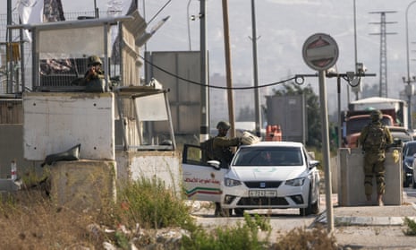 Israeli soldiers check a Palestinian car at a checkpoint in Hawara after the incident