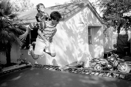 Young man with child on his back bouncing on a trampoline 