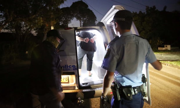 A handout picture released by NSW Police shows police making arrests during a raid at Merrylands in Sydney, Australia